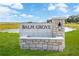 Stone sign at Balm Grove community entrance under a blue sky at 15238 Rainbow Quartz St, Wimauma, FL 33598