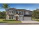 Two-story home with gray siding, stone accents, a two-car garage, manicured lawn, and a mature palm tree at 15238 Rainbow Quartz St, Wimauma, FL 33598
