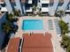 An aerial shot of a community pool surrounded by lounge chairs and palm trees at 171 Medallion Blvd # F, Madeira Beach, FL 33708