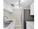 Bright kitchen featuring a stainless steel refrigerator and white cabinets at 171 Medallion Blvd # F, Madeira Beach, FL 33708