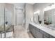Modern bathroom with dual sinks, walk-in shower, and neutral tile flooring at 17921 Nadine Pl, Nokomis, FL 34275