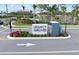 Community entrance monument sign for Legacy Groves with palm trees and colorful flowering shrubbery at 17921 Nadine Pl, Nokomis, FL 34275