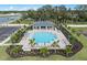 Aerial view of the community pool and outdoor lounge area with many chairs and palm trees at 17921 Nadine Pl, Nokomis, FL 34275