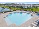 Aerial view of community pool with many lounge chairs and umbrellas with a nearby grassy area at 17921 Nadine Pl, Nokomis, FL 34275
