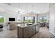 Open-concept kitchen and living area with island seating, stainless appliances, and plenty of light at 17921 Nadine Pl, Nokomis, FL 34275