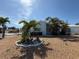 Charming home with tropical landscaping, complemented by lush palms and bright blue sky at 195 45Th Ave, St Pete Beach, FL 33706