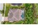Aerial view of the home features a pool, hot tub, tile roof, and mature landscaping at 19810 Prince Benjamin Dr, Lutz, FL 33549