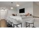 Modern bar area with white countertop, seating for five, pendant lights, and sleek black fixtures at 19810 Prince Benjamin Dr, Lutz, FL 33549