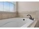 Close-up of a soaking tub with black hardware and tile backsplash at 19810 Prince Benjamin Dr, Lutz, FL 33549