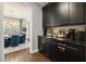 View of the dining room beyond butler's pantry with granite countertop and dark cabinets at 19810 Prince Benjamin Dr, Lutz, FL 33549
