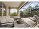 This screened patio features a cozy seating area with comfortable couch, hanging chair, and a modern fire pit at 19810 Prince Benjamin Dr, Lutz, FL 33549