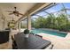 Covered outdoor dining and screened pool with attached spa with elegant design elements in the backyard at 19810 Prince Benjamin Dr, Lutz, FL 33549