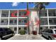 View of a multi-story condo building with a parking lot, palm trees, and clearly labeled units at 2077 Canal Dr # L35, Bradenton, FL 34207