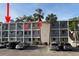 Exterior of a building with a parking lot, palm trees, and an arrow pointing to the featured condo unit at 2077 Canal Dr # L35, Bradenton, FL 34207