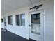 Exterior view of a building with white walls, windows, and a front door with a shark decoration on the wall at 2077 Canal Dr # L35, Bradenton, FL 34207