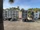 Exterior view of a condo building, parking lot, palm trees, and well-maintained landscaping at 2077 Canal Dr # L35, Bradenton, FL 34207