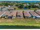 Aerial view of homes with screened patios on a lake, surrounded by trees at 2344 Pleasant Hill Ln, Holiday, FL 34691