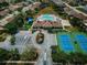 An aerial view of the community clubhouse featuring a pool, tennis courts, sand volleyball, and parking at 2344 Pleasant Hill Ln, Holiday, FL 34691
