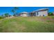 Expansive backyard with screened-in patios, palm trees and manicured lawn at 2344 Pleasant Hill Ln, Holiday, FL 34691