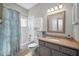 Updated bathroom features stylish vanity, mirror and shower with blue patterned shower curtain at 2344 Pleasant Hill Ln, Holiday, FL 34691