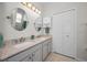 Bathroom featuring double sinks, granite countertops, a vanity, and a large mirror at 2344 Pleasant Hill Ln, Holiday, FL 34691