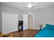 Well-lit bedroom with wood-look floors, closet and an open doorway at 2344 Pleasant Hill Ln, Holiday, FL 34691