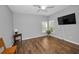 Bright bedroom featuring hardwood floors, neutral walls, large windows, and a ceiling fan at 2344 Pleasant Hill Ln, Holiday, FL 34691