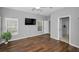 Bedroom showcasing wood floors, large windows, neutral colored walls, a ceiling fan, and TV at 2344 Pleasant Hill Ln, Holiday, FL 34691