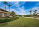 Community entrance sign with lush landscaping, manicured lawn, and tropical palm trees at 2344 Pleasant Hill Ln, Holiday, FL 34691