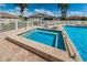 Relaxing hot tub next to a community pool surrounded by comfortable lounge chairs at 2344 Pleasant Hill Ln, Holiday, FL 34691