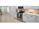 Modern kitchen with stainless steel appliances, white cabinets, quartz countertops, and tile backsplash at 2344 Pleasant Hill Ln, Holiday, FL 34691