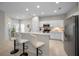 Open concept kitchen with breakfast bar seating, white cabinets and stainless steel appliances at 2344 Pleasant Hill Ln, Holiday, FL 34691