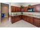 Clubhouse kitchenette with granite counters, dark wood cabinets, sink, and microwave at 2344 Pleasant Hill Ln, Holiday, FL 34691