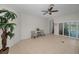 Spacious living room with tile floors, sliding glass doors, and a ceiling fan at 2344 Pleasant Hill Ln, Holiday, FL 34691