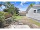 A backyard featuring a home with light siding, grass, and blue skies at 2415 E 20Th Ave, Tampa, FL 33605