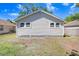 A backyard featuring a home with light siding, grass, and blue skies at 2415 E 20Th Ave, Tampa, FL 33605