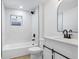 Modern bathroom featuring white marble tile, shower over tub, and stylish black fixtures at 2415 E 20Th Ave, Tampa, FL 33605