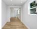 Open hallway showcasing wood-look flooring, neutral paint, and natural light at 2415 E 20Th Ave, Tampa, FL 33605