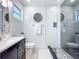 Modern bathroom featuring a glass enclosed shower with gray and white marble tile and a dark vanity sink at 2711 W Cordelia St, Tampa, FL 33607