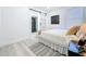 Bright bedroom with a queen size bed, light wood floors, and a view into the bathroom at 2711 W Cordelia St, Tampa, FL 33607
