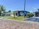 Quaint blue home with modern touches, surrounded by a lush lawn, and a brick-paved street at 2711 W Cordelia St, Tampa, FL 33607