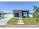 Charming blue home featuring a modern wood accent, well-manicured lawn, and inviting walkway at 2711 W Cordelia St, Tampa, FL 33607