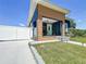 Modern home featuring a unique wood-accented facade, a white fence, and a well-maintained front lawn at 2711 W Cordelia St, Tampa, FL 33607