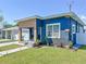 A blue house with a unique facade, landscaped lawn, and a cozy front patio area at 2711 W Cordelia St, Tampa, FL 33607