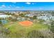Aerial view showcasing a community baseball field surrounded by green spaces and residential homes at 280 126Th Ave # 106, Treasure Island, FL 33706