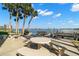 Outdoor patio with tables overlooking the waterfront view complete with palm trees and tranquil surroundings at 280 126Th Ave # 106, Treasure Island, FL 33706