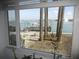 Inviting waterfront view from the window showcases a dock with a boat and swaying palm trees, enhancing the property's appeal at 280 126Th Ave # 106, Treasure Island, FL 33706