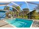 Screened-in pool area with a BBQ grill and a clear view of the backyard landscaping at 3500 Gussie St, Punta Gorda, FL 33950
