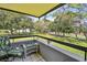 Balcony with tropical print furniture overlooking a lush green community lawn and landscaping at 36750 Us 19 N # 22212, Palm Harbor, FL 34684