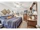 Cozy bedroom with wooden floors, decorative wall art, a ceiling fan, and a large dresser with mirror at 36750 Us 19 N # 22212, Palm Harbor, FL 34684